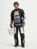 Alpinestars Harok V2 Drystar Gear Set, adventure touring motorcycle gear set in black, gray, and white, front studio view of a model wearing the waterproof jacket and matching pants while holding a white helmet.