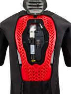Alpinestars Tech-Air 5 Plasma Airbagsysteem, binnenaanzicht met de geïnstalleerde zwarte vervangende canister en elektronische besturingseenheid, geïntegreerd in een felrode Nucleon Plasma rugprotector in een zwart beschermend vest