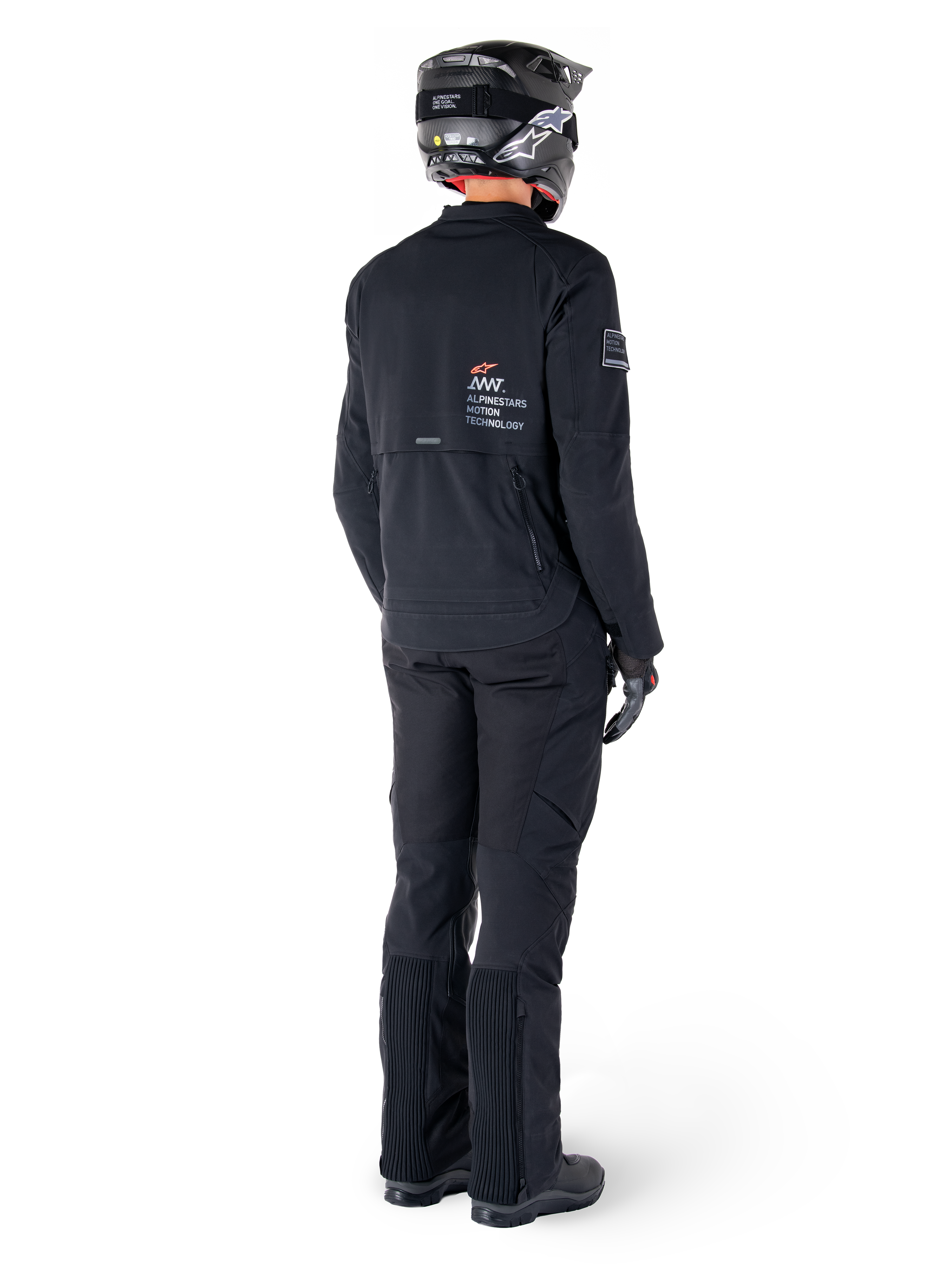 Alpinestars AMT-8 Stretch Drystar® XF Jas, zwart, achteraanzicht van een motorrijder die de jas draagt met bijpassende zwarte broek en een zwarte helm, voorzien van 'Alpinestars Motion Technology' branding op de rug, technisch stretchmateriaal voor adventure motorrijden