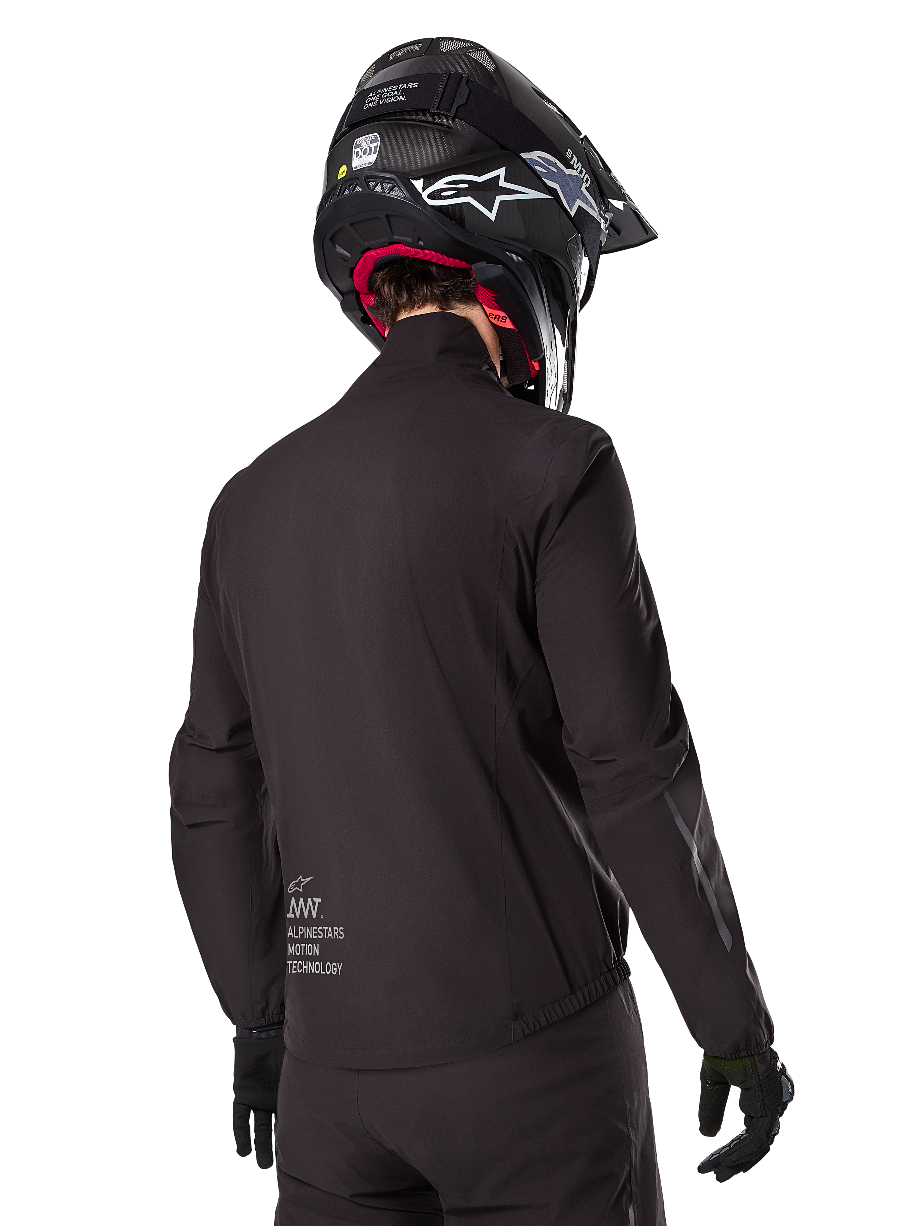 Alpinestars AMT-8 Stretch Drystar® XF voering, zwarte waterdichte voering voor motorjas, achteraanzicht van een rijder met zwarte helm en handschoenen, voorzien van Alpinestars Motion Technology-branding op de onderrug, minimalistisch en functioneel ontwerp voor adventure ritten.