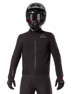 Alpinestars AMT-8 Stretch Drystar® XF liner, zwarte waterdichte motorvoering, voorzien van een ritssluiting aan de voorzijde en een elastische taille, AMT-logo op de borst en Drystar XF-branding op de mouw, gedragen met een zwarte helm en handschoenen.