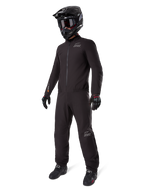Alpinestars AMT-8 Stretch Drystar® XF Liner, zwart waterdicht motorpak, gedragen met zwarte helm, motorbril en handschoenen, voorzien van AMT- en Drystar XF-branding, functionele adventure-uitrusting voor bescherming in alle weersomstandigheden.