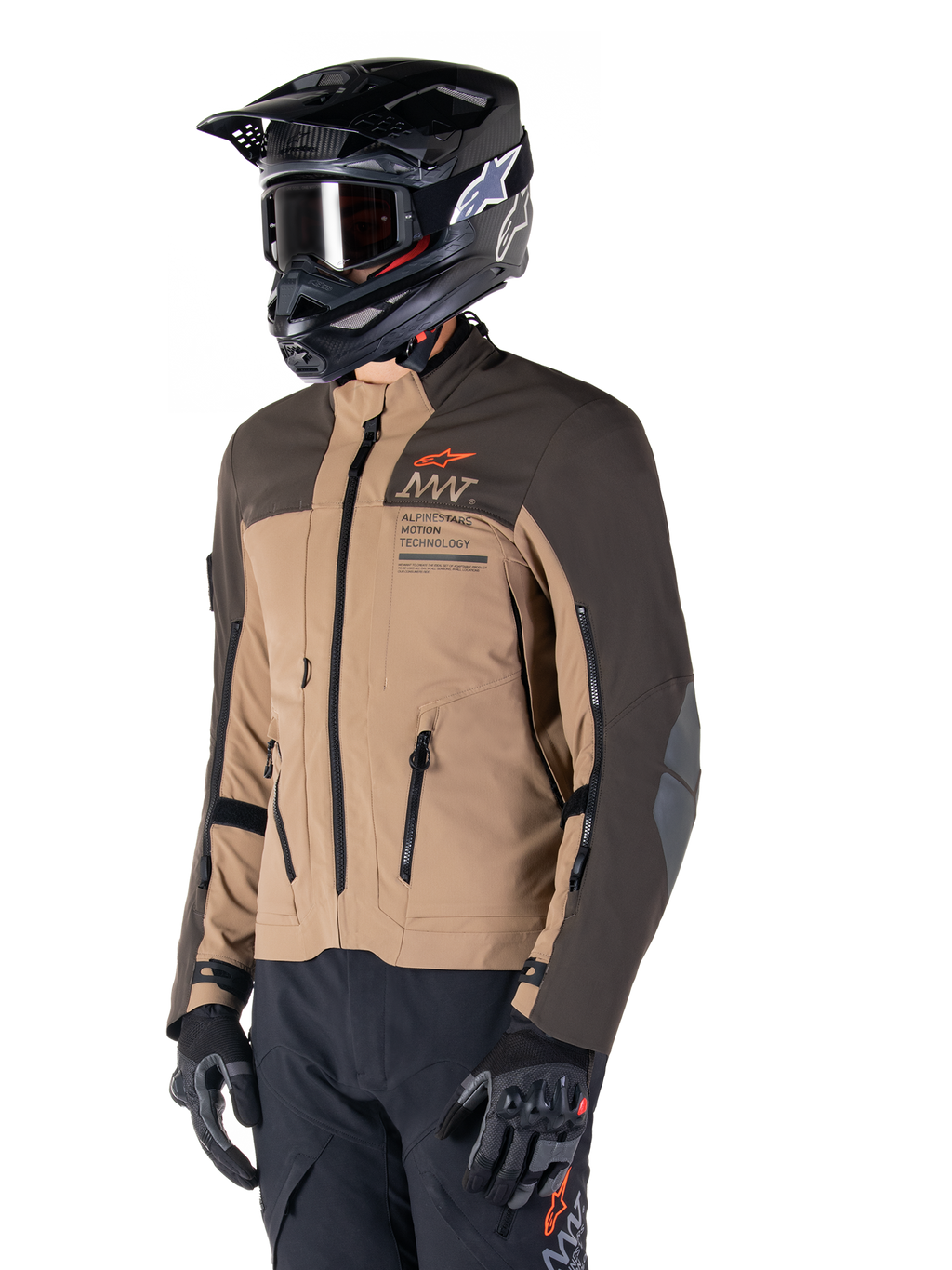 Alpinestars AMT-8 Stretch Drystar® XF Jas, adventure motorjas, donkerbruin en donker khaki, gedragen met een zwarte off-road helm en crossbril, voorzien van Alpinestars Motion Technology-branding en ventilatieopeningen met ritssluiting.