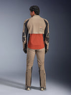Alpinestars AMT-8 Stretch Drystar® XF Jas, Walnut Rust Black, achteraanzicht op een rijder met bijpassende adventure broek en handschoenen, voorzien van een opvallend roestkleurig achterpaneel, walnootkleurige bovendelen en zwarte stretchaccenten, ontworpen voor lange afstandsritten.