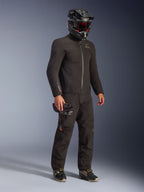 Alpinestars AMT-8 Stretch Drystar® XF Jas in zwart, gedragen als onderdeel van een complete motoroutfit met bijpassende broek en een zwarte helm, voorzien van een strak textielontwerp met oranje Drystar XF-branding op de mouw, ideaal voor adventure touring.