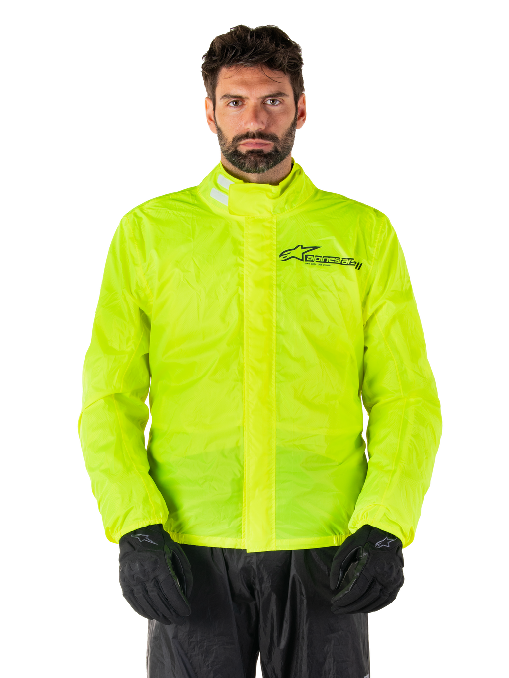 Alpinestars Hurricane Rain V2 Jacket, motorregenjas, neongeel, gedragen door een model met zwarte broek en handschoenen, hoge kraag met reflecterende tabs, stormflap aan de voorzijde met Alpinestars-logo, waterdichte kleding met hoge zichtbaarheid