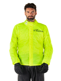 Alpinestars Hurricane Rain V2 Jacket, motorregenjas, neongeel, gedragen door een model met zwarte broek en handschoenen, hoge kraag met reflecterende tabs, stormflap aan de voorzijde met Alpinestars-logo, waterdichte kleding met hoge zichtbaarheid