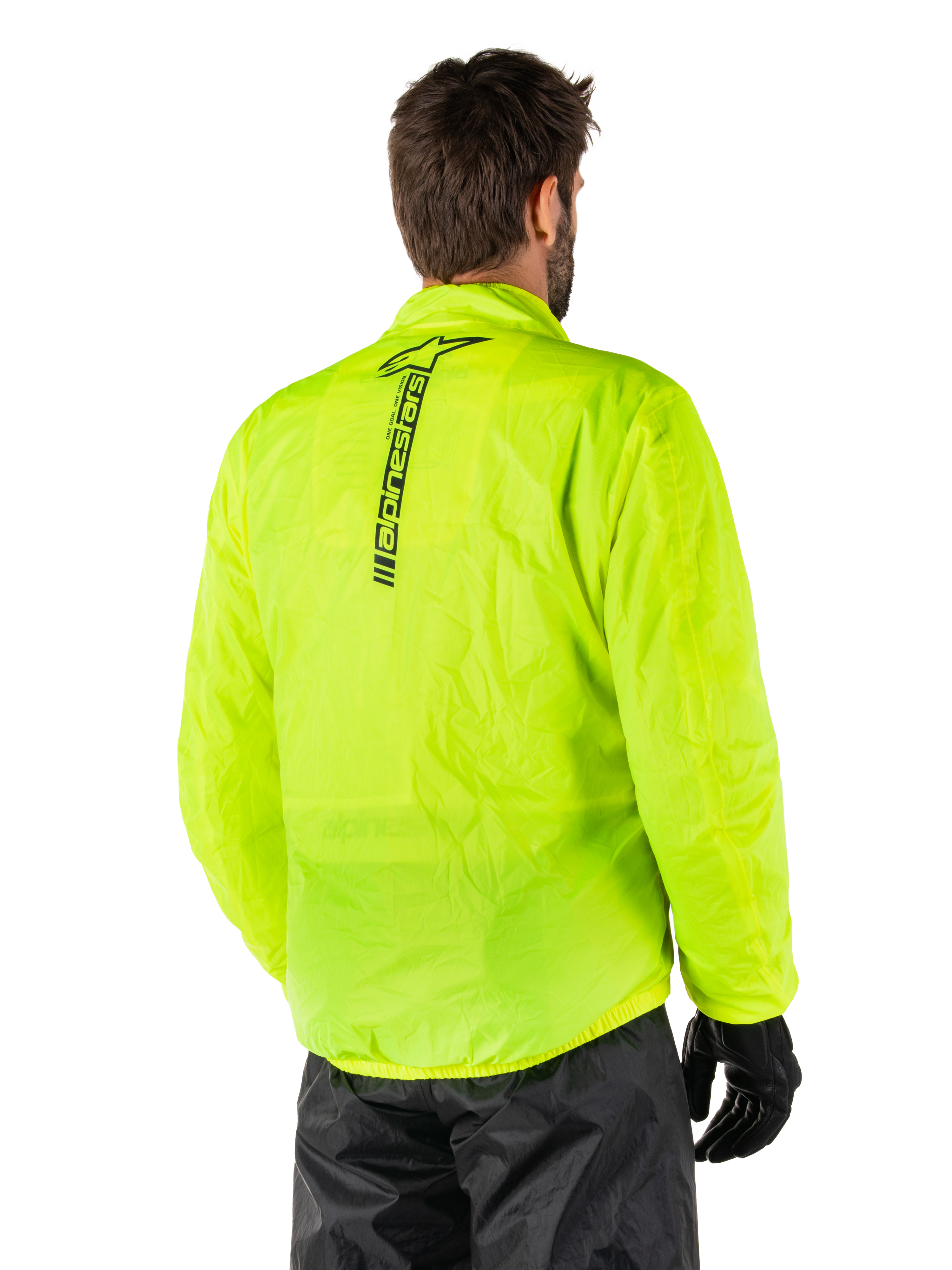 Alpinestars Hurricane Rain V2 Jas, Yellow Fluo, achteraanzicht gedragen door mannelijk model, met verticaal zwart Alpinestars-woordmerk op het midden van de rug, elastische taille en manchetten, waterdicht en opvouwbaar ontwerp