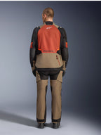 Alpinestars Andes V4 Drystar® Jas, Walnut Rust Black, achteraanzicht van touringmotorjas met roestkleurig bovenpaneel op de rug en walnootkleurig onderste gedeelte, gedragen met bijpassende adventure-broek en zwarte laarzen