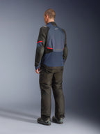 Alpinestars Andes V4 Drystar® Jas, Night Navy en Mood Indigo met zwarte panelen en rode accenten, driekwart achteraanzicht, gedragen met bijpassende zwarte adventure motorbroek en laarzen, technische textielconstructie met Alpinestars-logo op de bovenrug, verlengde achterzoom voor extra bedekking.