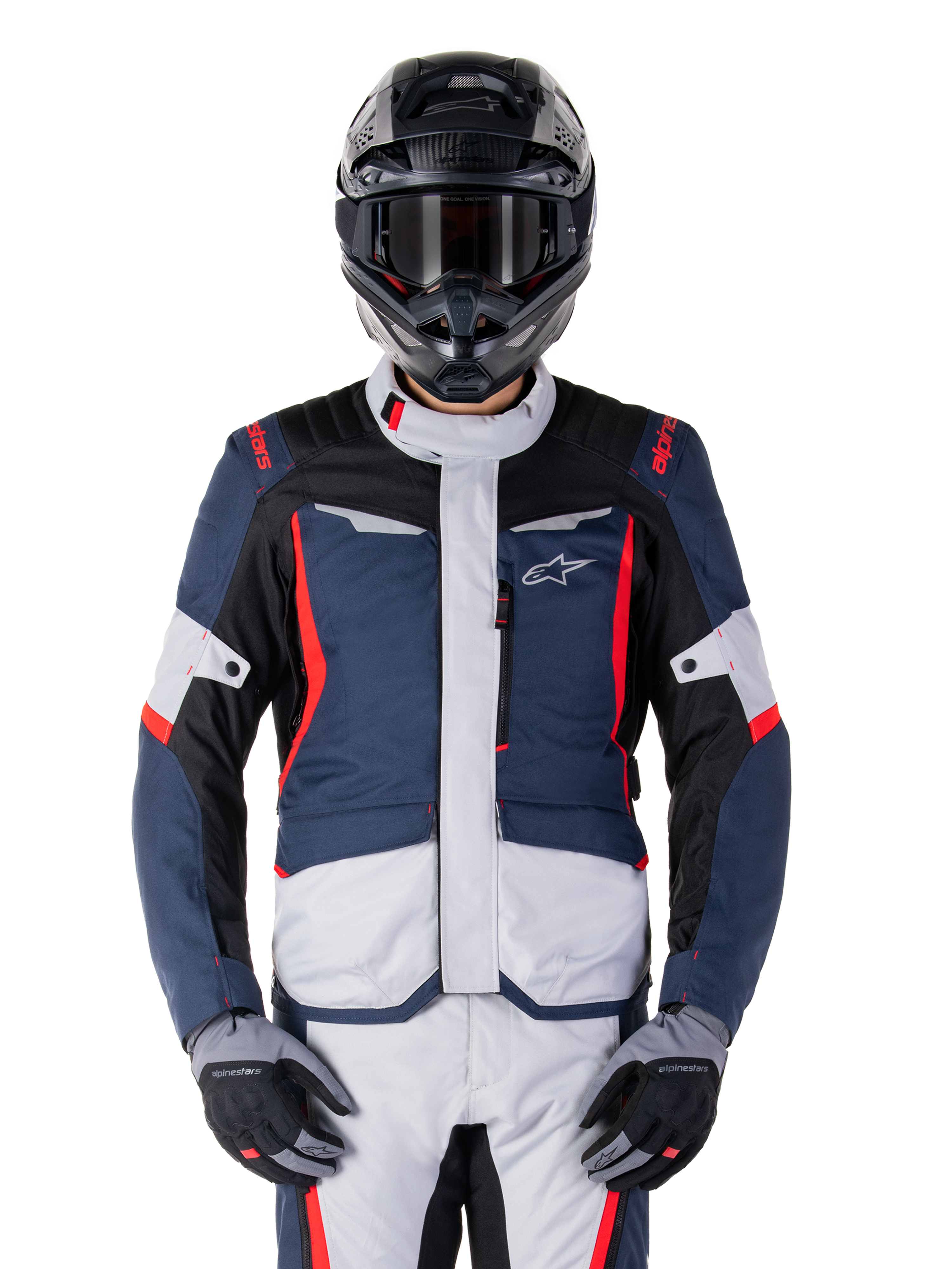Alpinestars ST-1 waterdichte jas, motor adventure touring jas, donkerblauw en zwart met lichtgrijze panelen en felrode accenten, gedragen met bijpassende broek en zwarte helm, voorzien van sterlogo op de borst en een duurzame textielconstructie