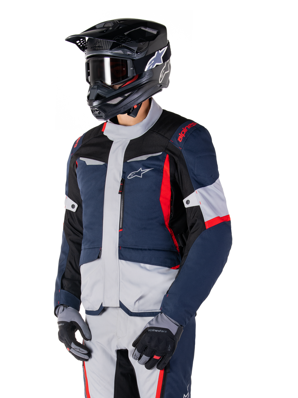 Alpinestars ST-1 Waterproof Jacket, adventure touring motorjas in donkerblauw, zwart en felrood, gedragen met een zwarte helm en grijze handschoenen, voorzien van een modern design met functionele zakken en Alpinestars-branding.