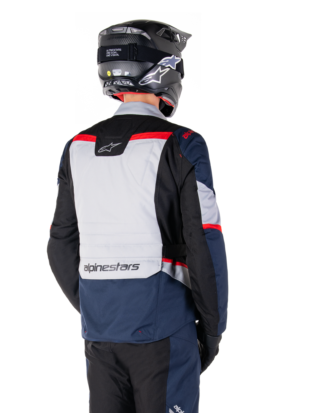 Alpinestars ST-1 Waterproof Jacket, donkerblauw, zwart en felrood, achteraanzicht van een rijder met een zwarte adventure-helm, voorzien van lichtgrijze panelen en Alpinestars-branding, adventure touring motorkleding