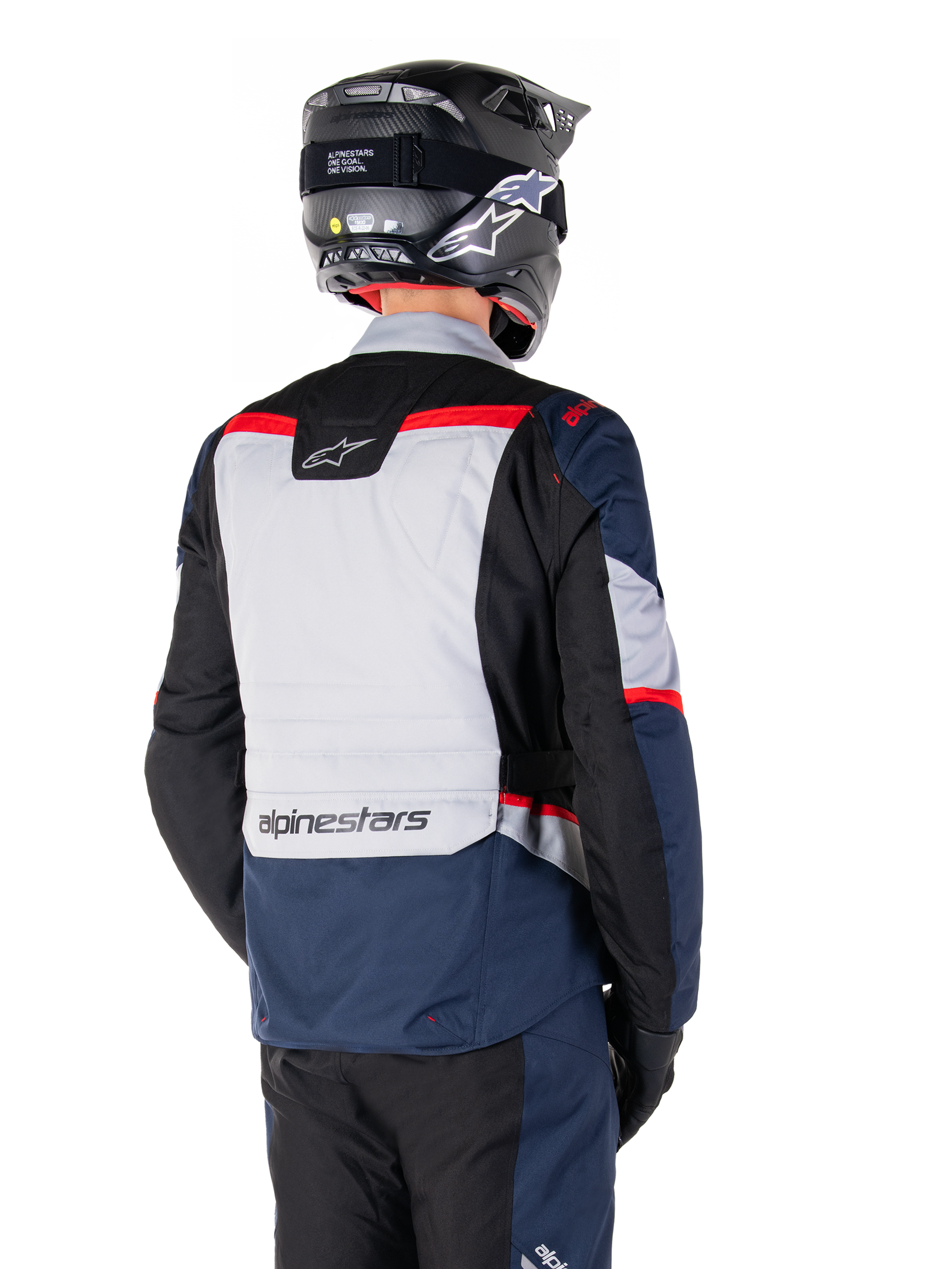 Alpinestars ST-1 Waterproof Jacket, donkerblauw, zwart en felrood, achteraanzicht van een rijder met een zwarte adventure-helm, voorzien van lichtgrijze panelen en Alpinestars-branding, adventure touring motorkleding