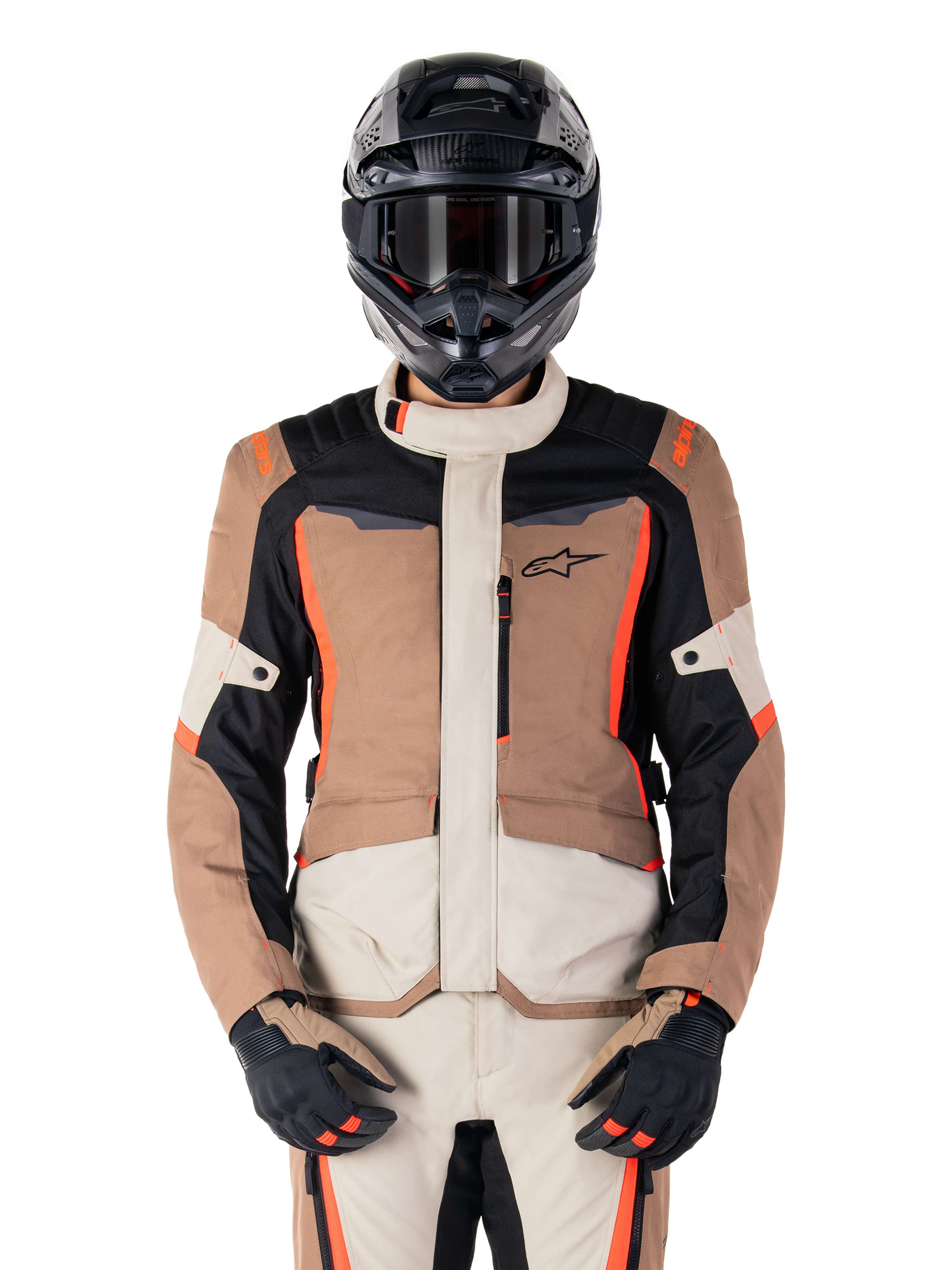 Alpinestars ST-1 Waterproof jas, Dark Khaki Sand Black Red Fluo, gedragen door een motorrijder met een zwarte helm en handschoenen, adventure touring motorkleding met beige en bruine panelen en felle fluo rode accenten, vooraanzicht op een witte achtergrond.