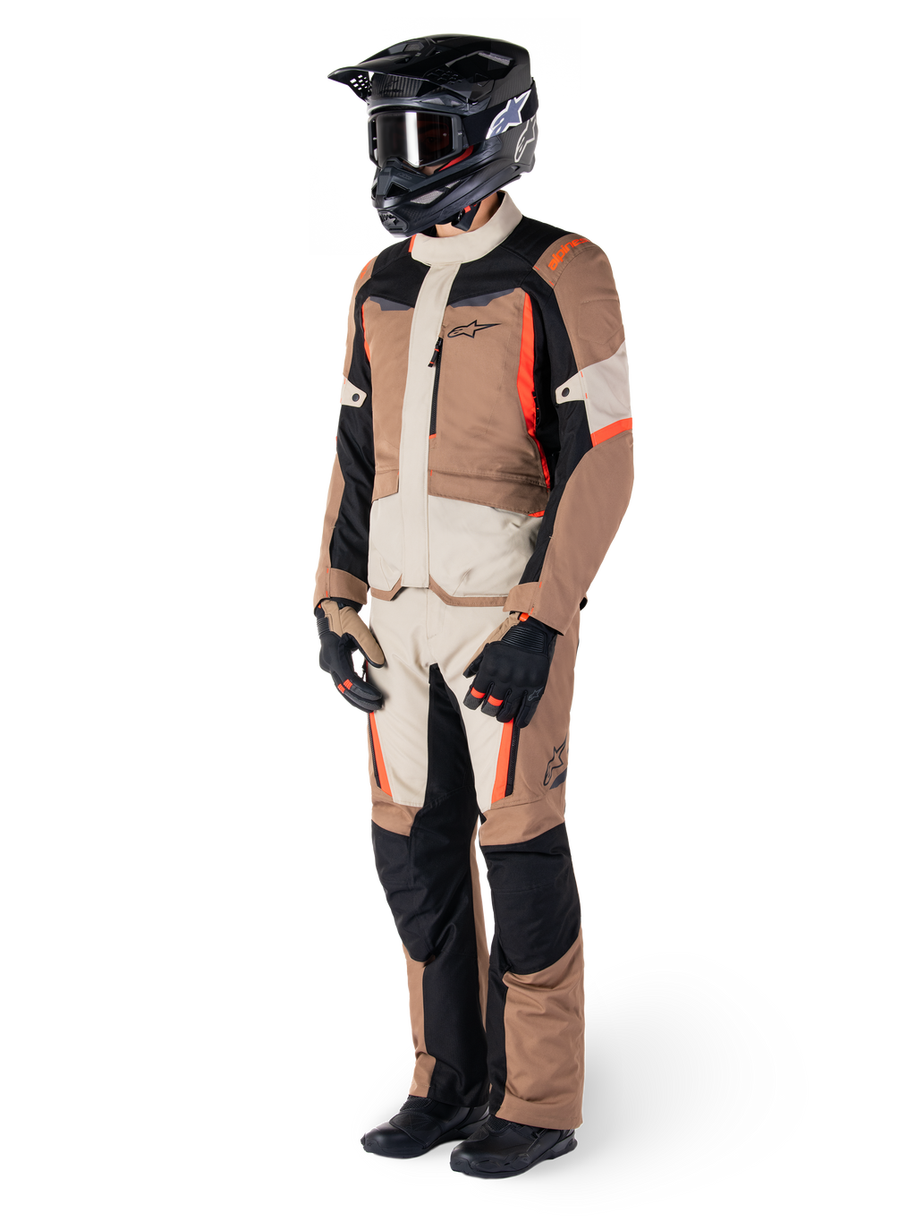 Alpinestars ST-1 Waterproof Jas, Dark Khaki Sand Black Red Fluo, gedragen door een rijder in volledige adventure touring-uitrusting met bijpassende broek, zwarte helm, motorbril, handschoenen en laarzen, technische all-weather motoroutfit