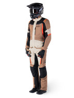 Alpinestars ST-1 Waterproof Jas, Dark Khaki Sand Black Red Fluo, gedragen door een rijder in volledige adventure touring-uitrusting met bijpassende broek, zwarte helm, motorbril, handschoenen en laarzen, technische all-weather motoroutfit