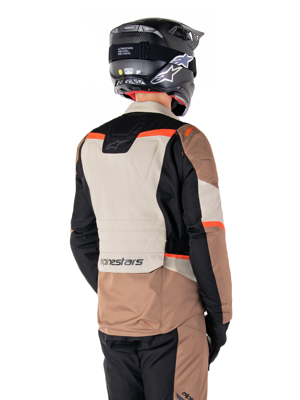 Alpinestars ST-1 Waterproof Jas, Adventure Touring Jas, Dark Khaki Sand Black Red Fluo, achteraanzicht met kleurvlakken van textiel, fluorescerend rode accenten en Alpinestars-logo op de onderrug, gedragen door een rijder met een zwarte helm.