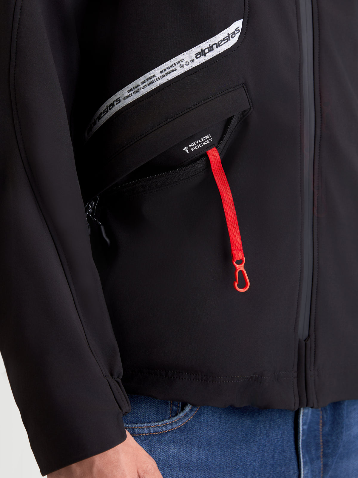 Alpinestars C 5 Drystar Jas, urban textiel motorjas voor heren, zwart, close-up van de keyless pocket met een rode ritstrekker en merkgraphics op de borst