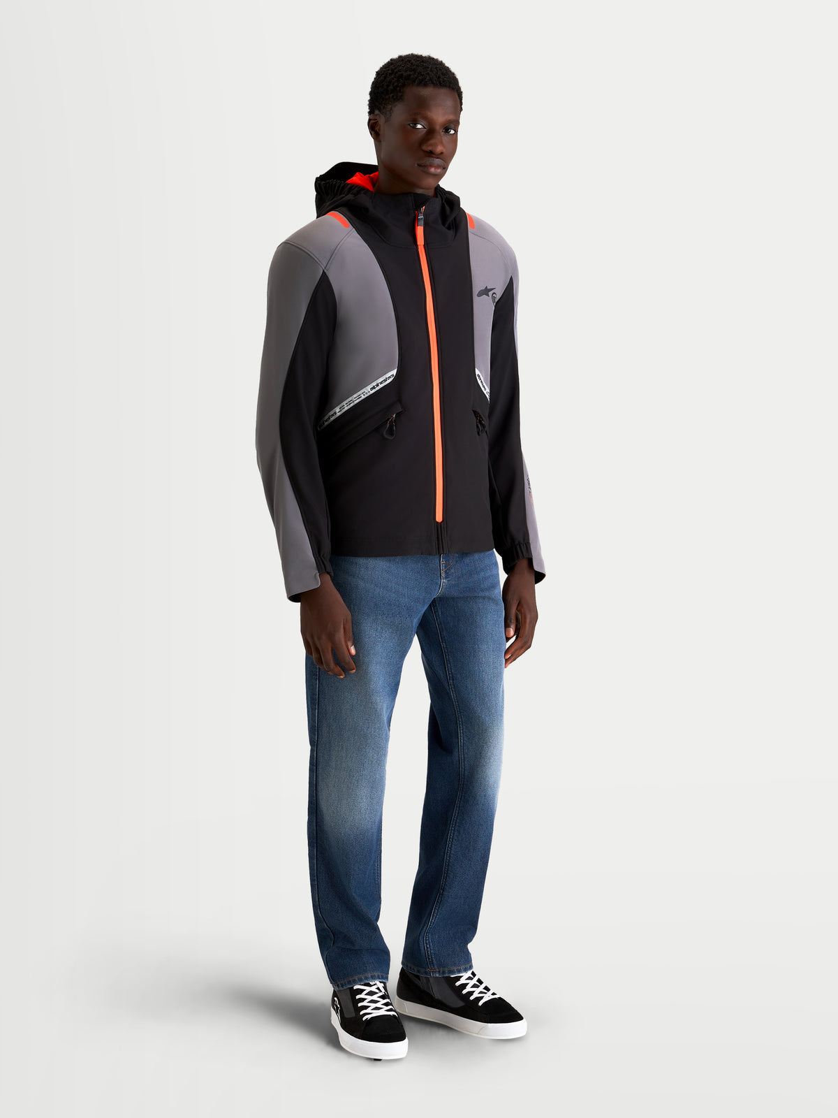Alpinestars C 5 Drystar jas, heren urban contemporary motorjas, zwart en donkergrijs met feloranje ritssdetails en geïntegreerde capuchon, gedragen door model