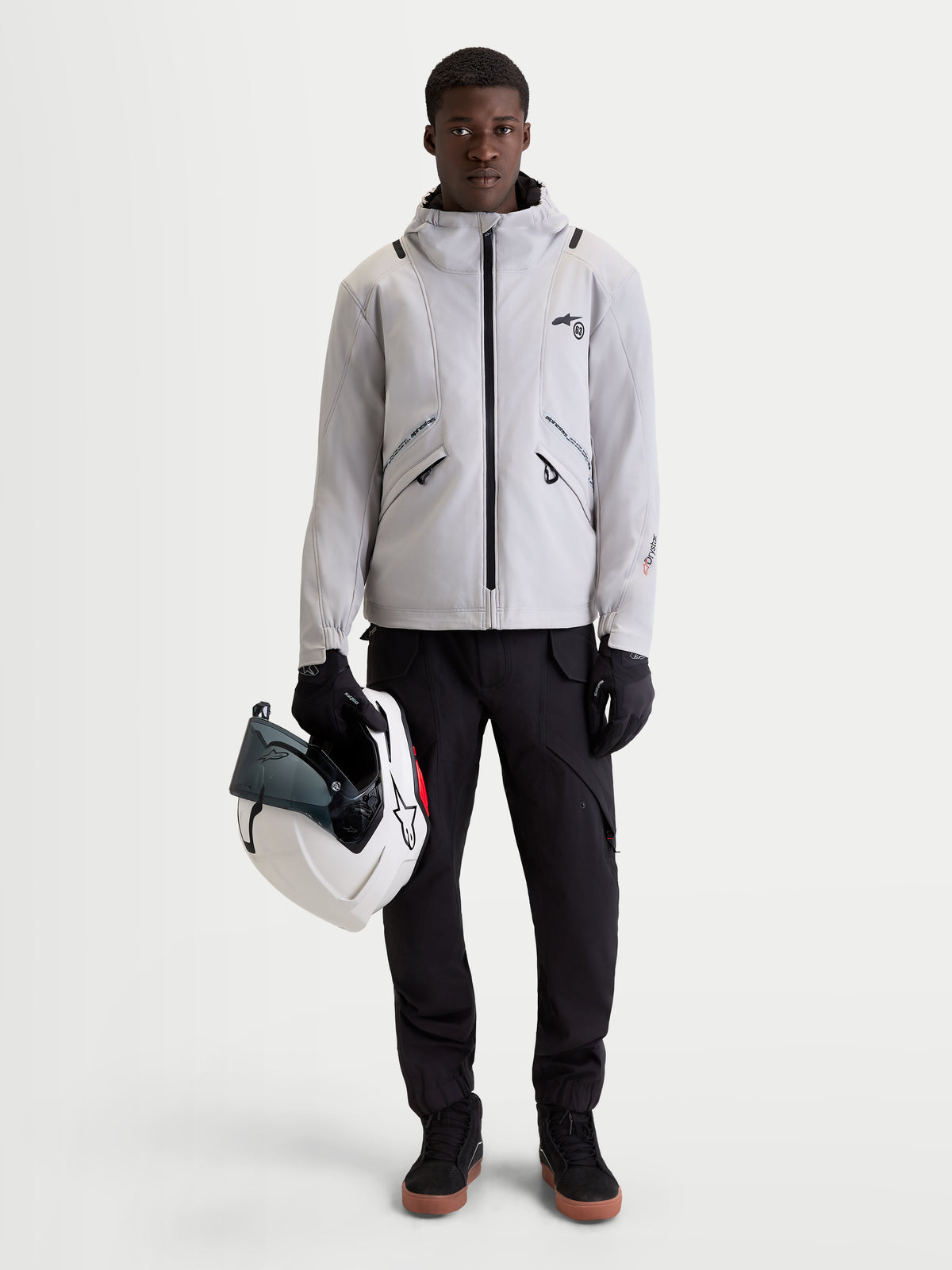 Alpinestars C-5 Drystar Jacket, men's urban contemporary motorcycle textile jacket in light gray and black, front view of a model wearing the waterproof jacket, integrated hood, and holding a helmet
