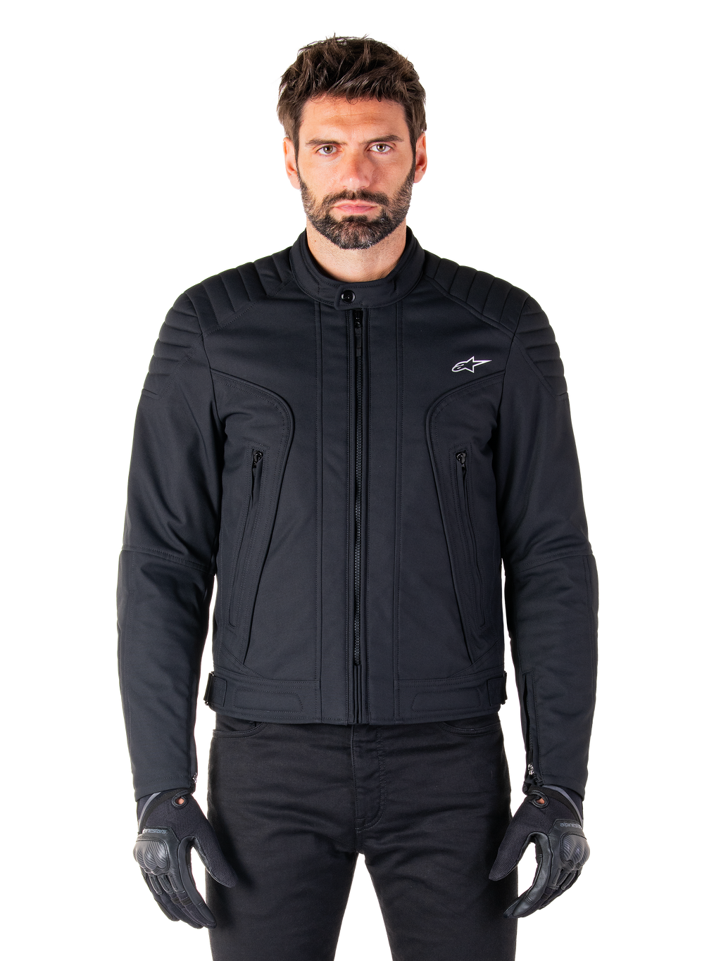 Alpinestars Clayton WR Jacket, zwarte motorjas, gedragen door een model, voorzien van gewatteerde schouderdetails en technische graphics, centrale Vislon-rits, verticale zakken met rits, klein wit logo op de borst, stedelijke motorkleding voor weggebruik