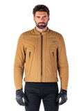 Alpinestars Clayton WR jas, urban motorjas, Utility Brown Light Gold, waterbestendig textiel met gewatteerde schouders, hoge kraag, zwarte ritsdetails en logo op de borst, gedragen met zwarte beschermende handschoenen en broek