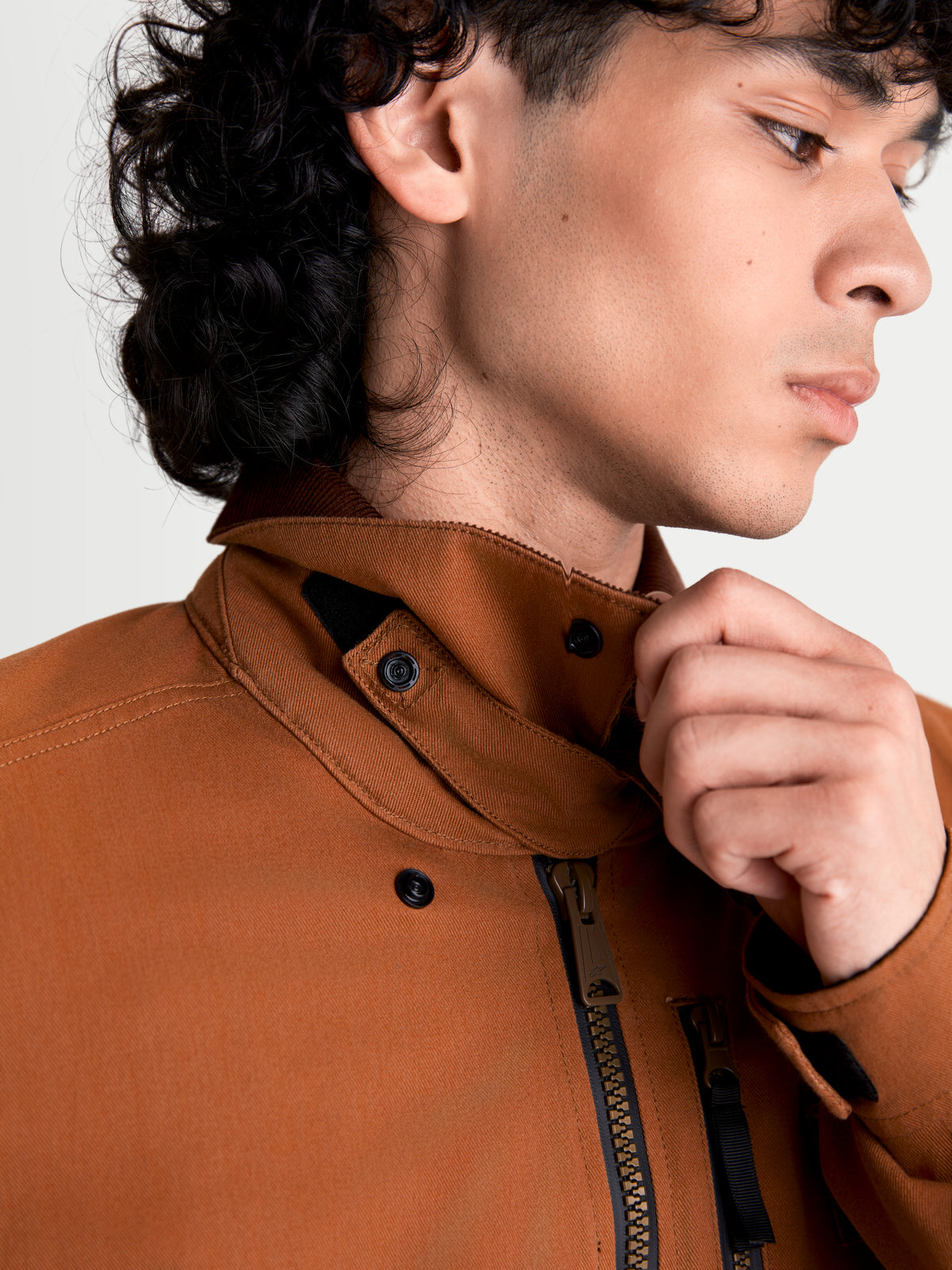 Alpinestars Mustang Wp jas, urban motorjas voor heren in donkerroestbruin en donkerbruin, detailopname van de stretch twill kraag en voorste ritssluiting gedragen door een model