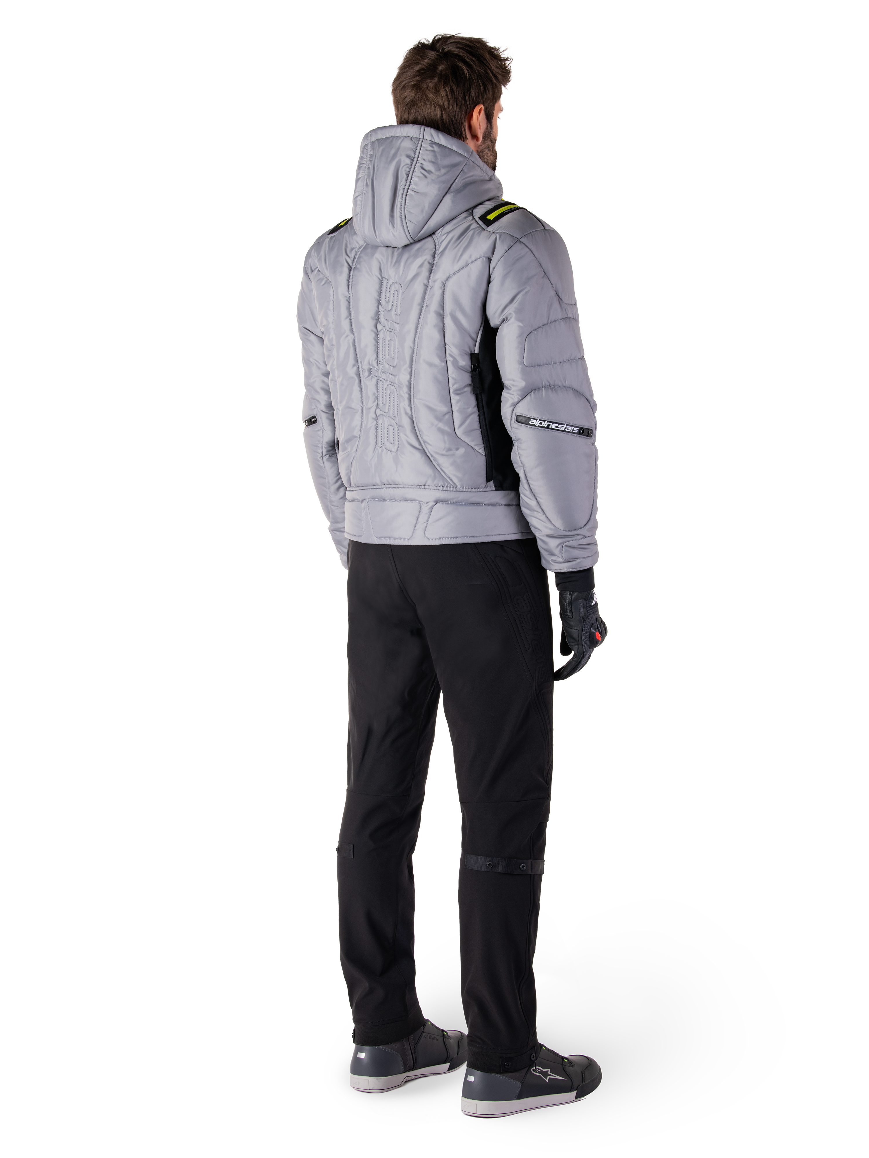 Alpinestars Mohobbs Waterproof Jacket, Lunar Gray Lime Punch, achteraanzicht van gewatteerde motorjas in bomberstijl met capuchon, voorzien van Alpinestars-woordmerk op de rug, gedragen met zwarte motorbroek en handschoenen, urban moto streetwear