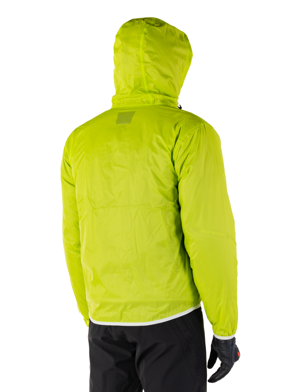 Alpinestars Mohobbs Waterproof Jacket, opvouwbare regenvoering in Lime Punch, achteraanzicht van de neongroene waterdichte laag met capuchon, gedragen met zwarte motorbroek en handschoenen
