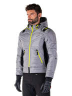 Alpinestars Mohobbs Waterproof Jacket, Lunar Gray Lime Punch, gewatteerd bomberjack voor heren met neongele ritsen en trekkoordaccenten, gedragen met zwarte motorbroek en handschoenen, modern urban moto streetwear-ontwerp met een capuchon