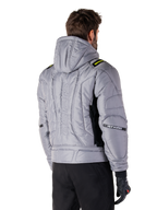 Alpinestars Mohobbs Waterproof Jas in Lunar Gray en Lime Punch, achteraanzicht op een model, gewatteerd bomberjack met verticaal astars-logo in reliëf op de rug, limegroene schouderaccenten, met capuchon, gedragen met zwarte motorbroek en handschoenen.