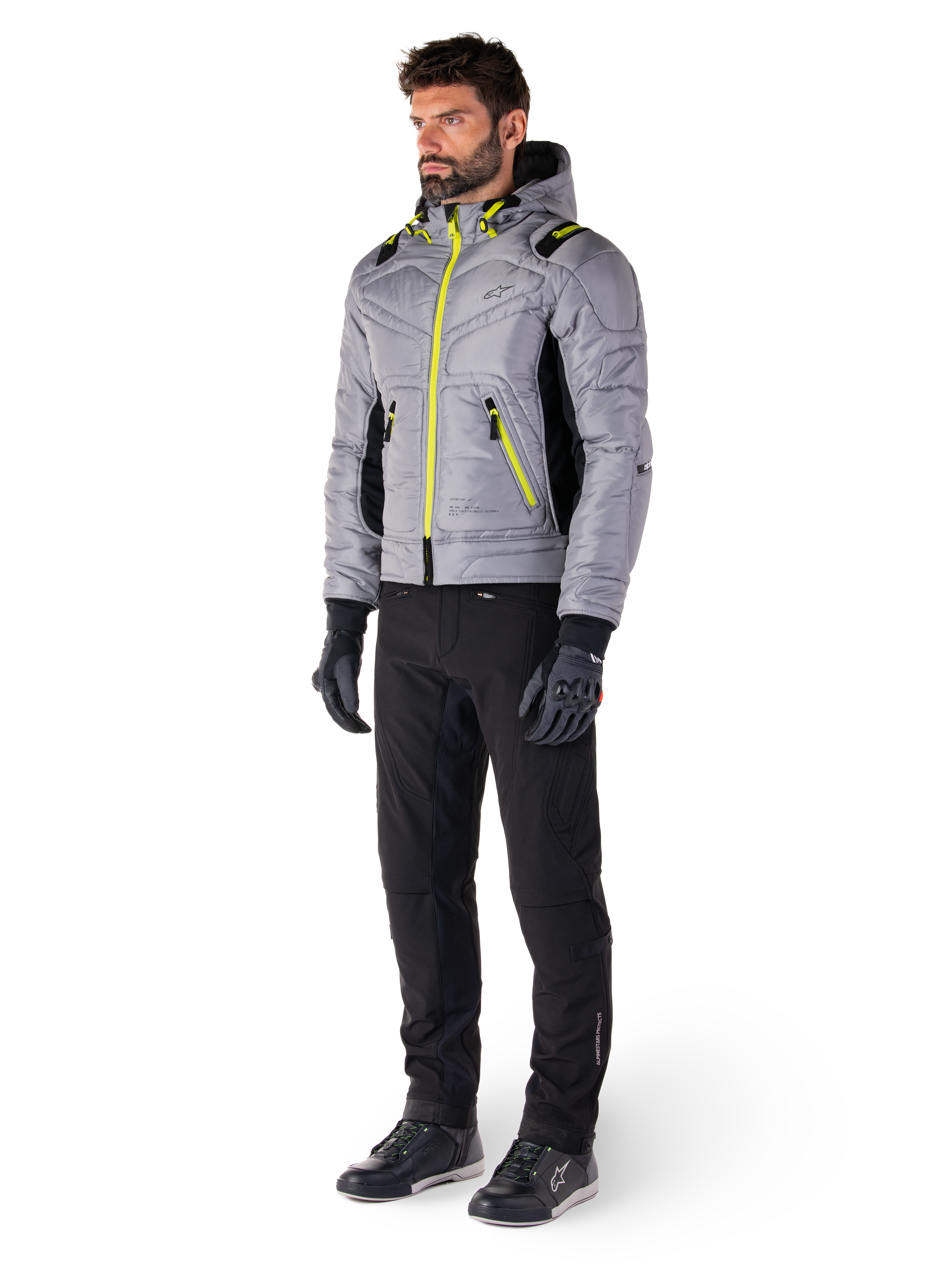 Alpinestars Mohobbs Waterproof Jacket in Lunar Gray en Lime Punch, gewatteerd bomber-stijl motorjas met neon accenten, gedragen door model met zwarte motorbroek en handschoenen, op urban streetwear geïnspireerde beschermende kleding