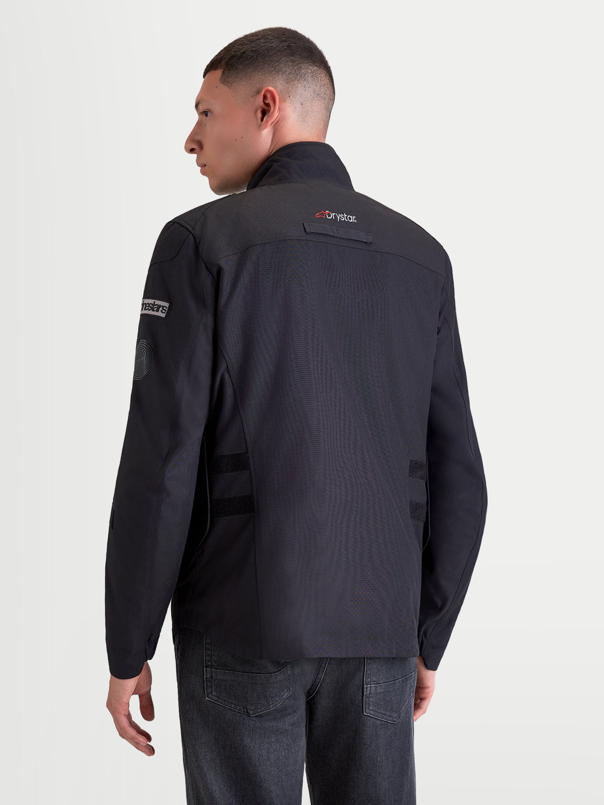 Alpinestars Altan Drystar jas, heren motorjas voor stedelijk gebruik in zwart, achteraanzicht op model met het waterdichte rijjack voorzien van Drystar-technologie en geïntegreerde warme kraag