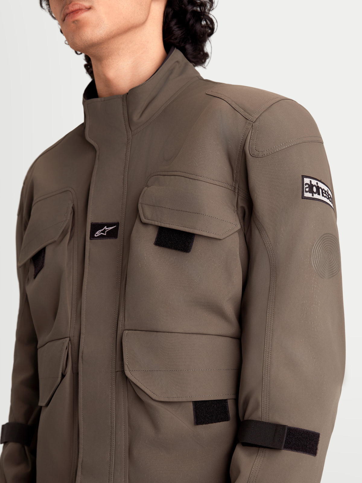 Alpinestars Altan Drystar jas, heren urban motorjas in walnootbruin en zwart, detailweergave van de cargozakken, mat polykatoenen constructie en schouderbescherming gedragen door een model