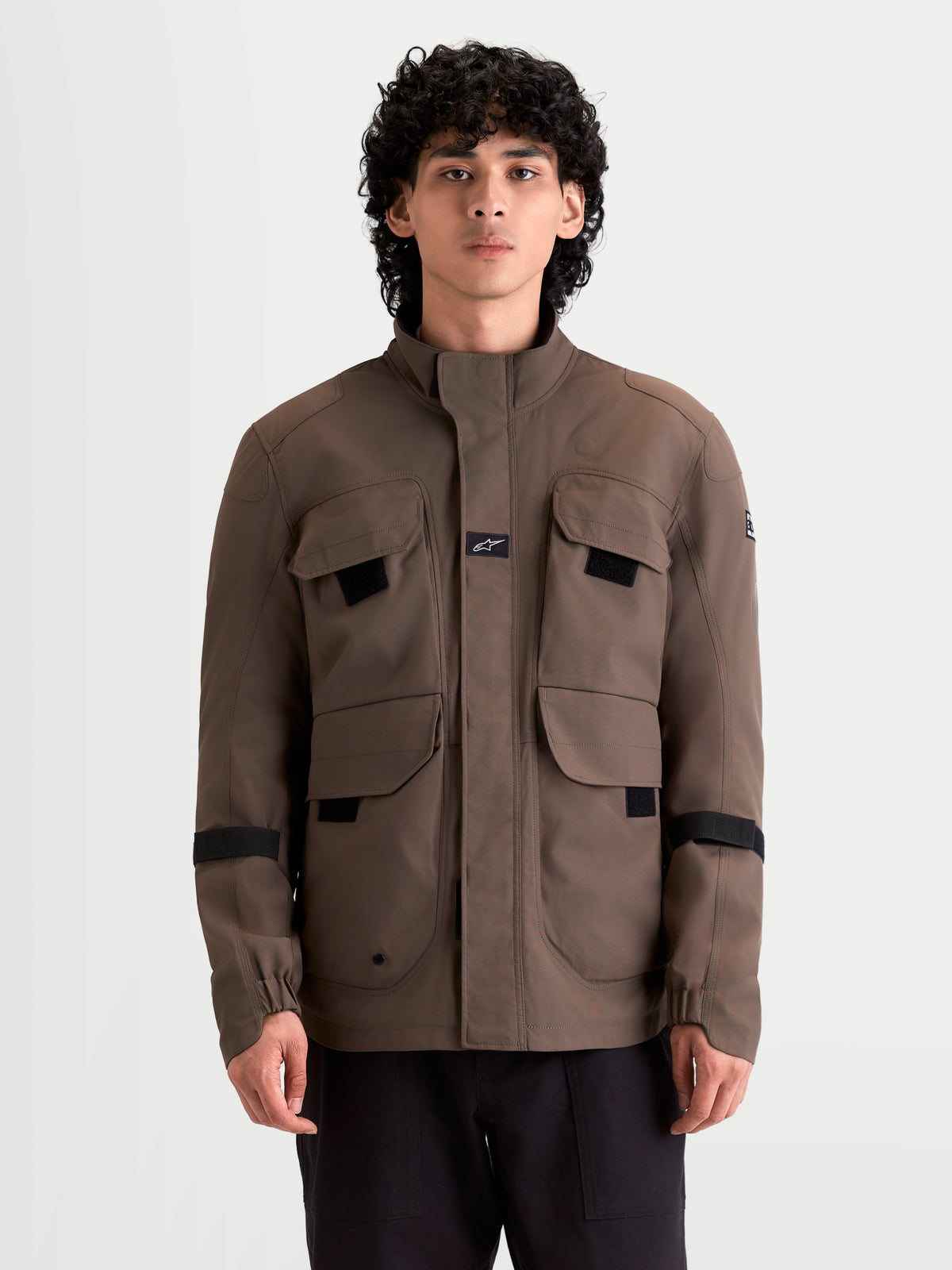 Alpinestars Altan Drystar jas, heren urban contemporary waterdichte motorjas in walnootbruin, voorkant gedragen door een model met field-jacket opbergzakken en warme kraagconstructie