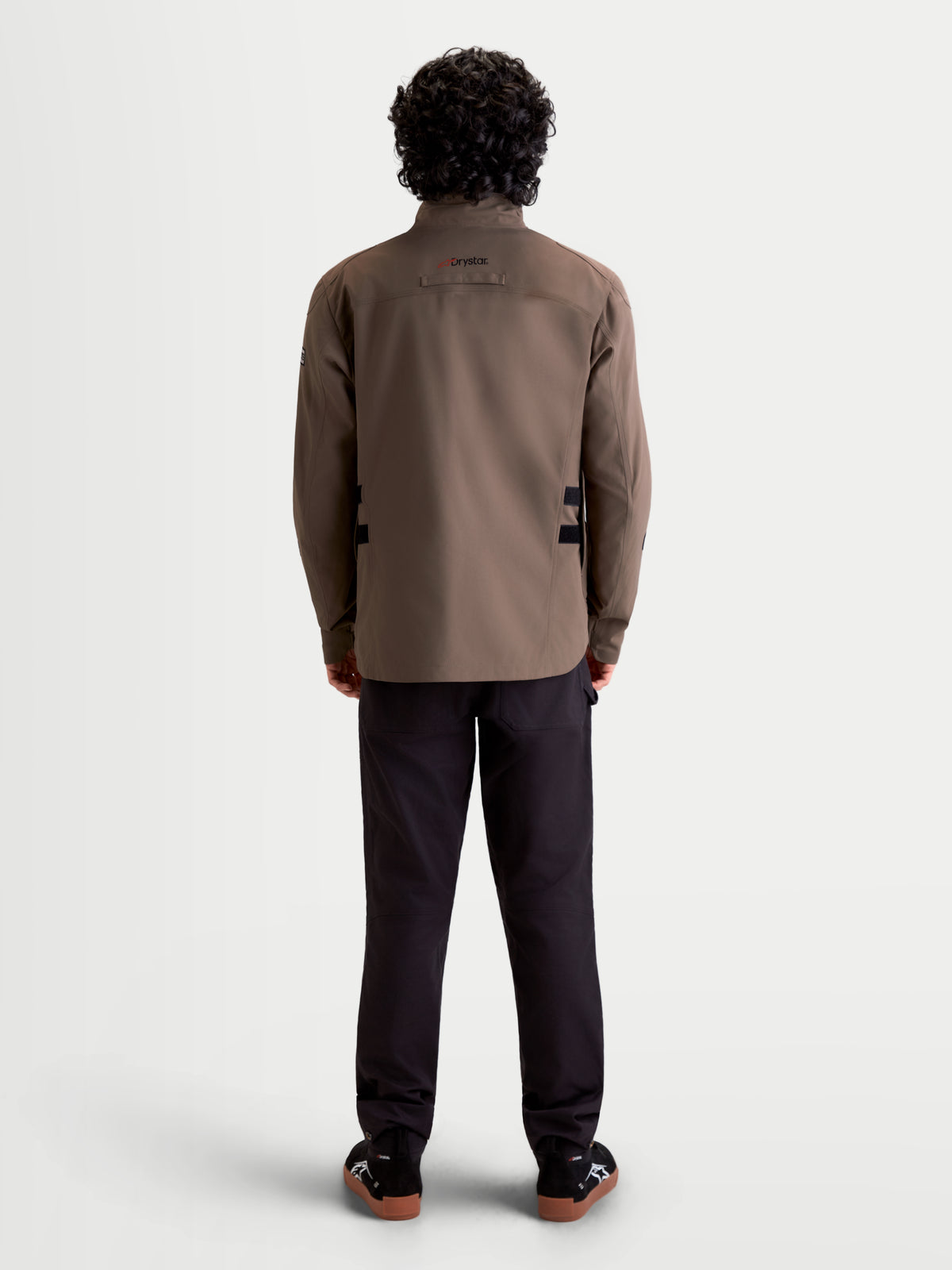 Alpinestars Altan Drystar jas, heren urban motorjas in walnootbruin en zwart, achteraanzicht op model met waterdichte veldjasconstructie en hoge kraag