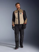 Male model wearing Alpinestars Andes Pro Drystar® XF Jacket in Walnut Aluminum, tan and black adventure touring jacket with red accents, styled with black motorcycle pants, gloves, and boots, full-body studio shot for protective riding gear.