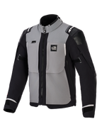 Alpinestars Andes Pro Drystar® XF jas, adventure motorjas, donkergrijs en zwart, voorzien van grijze borstpanelen met zwarte mouwen en zijkanten, 'ALL TERRA' branding op de borst, Alpinestars-logo op de schouders, technische textielconstructie met ventilatieritsen en verstelbare manchetten.