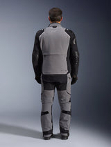 Alpinestars Andes Pro Drystar® XF Jacket, Dark Gray Black, back view of a rider wearing matching pants, adventure touring motorcycle jacket featuring a large gray back panel, black articulated sleeves with protection, and a rear storage compartment