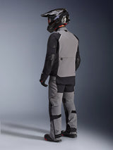 Alpinestars Andes Pro Drystar® XF Jacket, Adventure Motorcycle Jacket, Dark Gray and Black, rear view showing gray back panel and black sleeves, worn with matching pants and black helmet, technical all-weather riding gear