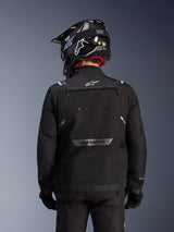 Alpinestars Cusco Drystar® Jacket, Black, Back view of a rider wearing a black helmet and gloves, features large ventilation panels, white logo on the neck and reflective branding on the lower back, adventure touring gear