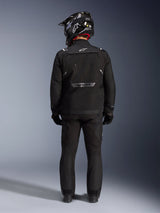 Alpinestars Cusco Drystar Jacket, Motorcycle Adventure Jacket, Black, back view worn with matching pants and a black and white helmet, featuring reflective Alpinestars branding and large ventilation panels, durable textile construction for road adventure touring
