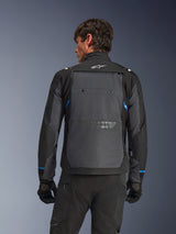 Alpinestars Cusco Drystar® Jacket, motorjas, zwart en diepgrijs, achteraanzicht op een model met groot grijs achterpaneel, wit Alpinestars-logo en blauwe accenten op de mouwen