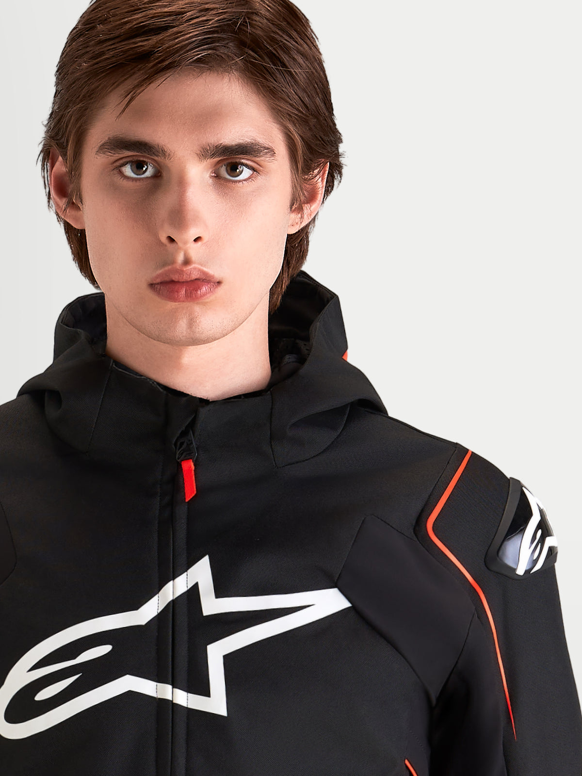 Alpinestars Zaca V 2 Waterproof Jas, heren waterdichte motorjas, zwart en fluorrood, met DFS-schouderbescherming en groot borstlogo, close-up portret van mannelijke rijder