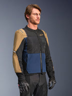 Alpinestars ST-2 Air motorjas, diepblauw, donkerkhaki en zwart, voorzien van high-flow mesh ventilatiepanelen en 'Alpinestars Exploration Equipment' branding, gedragen met zwarte motorhandschoenen, modern adventure touring ontwerp