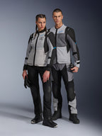 Man en vrouw in Alpinestars Stella ST-2 Air jassen en bijpassende technische broeken, Ice Gray en zwarte kleurstelling met blauwe accenten, voorzien van mesh-ventilatie en 'ALPINESTARS EXPLORATION EQUIPMENT' branding, studiofoto van koppel