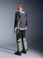 Mannelijk model van achteren die de Alpinestars ST-2 Air Jas draagt in Ice Gray, Dark Gray en Black, met een groot grijs mesh rugpaneel, blauwe logo-accenten en bijpassende motorbroek voor zomerse toertochten.