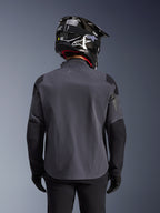 Alpinestars Maxdura Drystar®XF Laminated Armored Shell, adventure motorjas, Deep Gray Black, achteraanzicht met technische textielconstructie en versterkte panelen, gedragen met een zwarte carbon helm, zwarte motorbroek en handschoenen