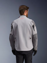 Alpinestars Maxdura Drystar®XF Laminated Armored Shell, back view of adventure motorcycle jacket, Mid Gray and Dark Gray, featuring a red star logo on the collar and white vertical branding on the sleeve, worn with black riding gloves and pants